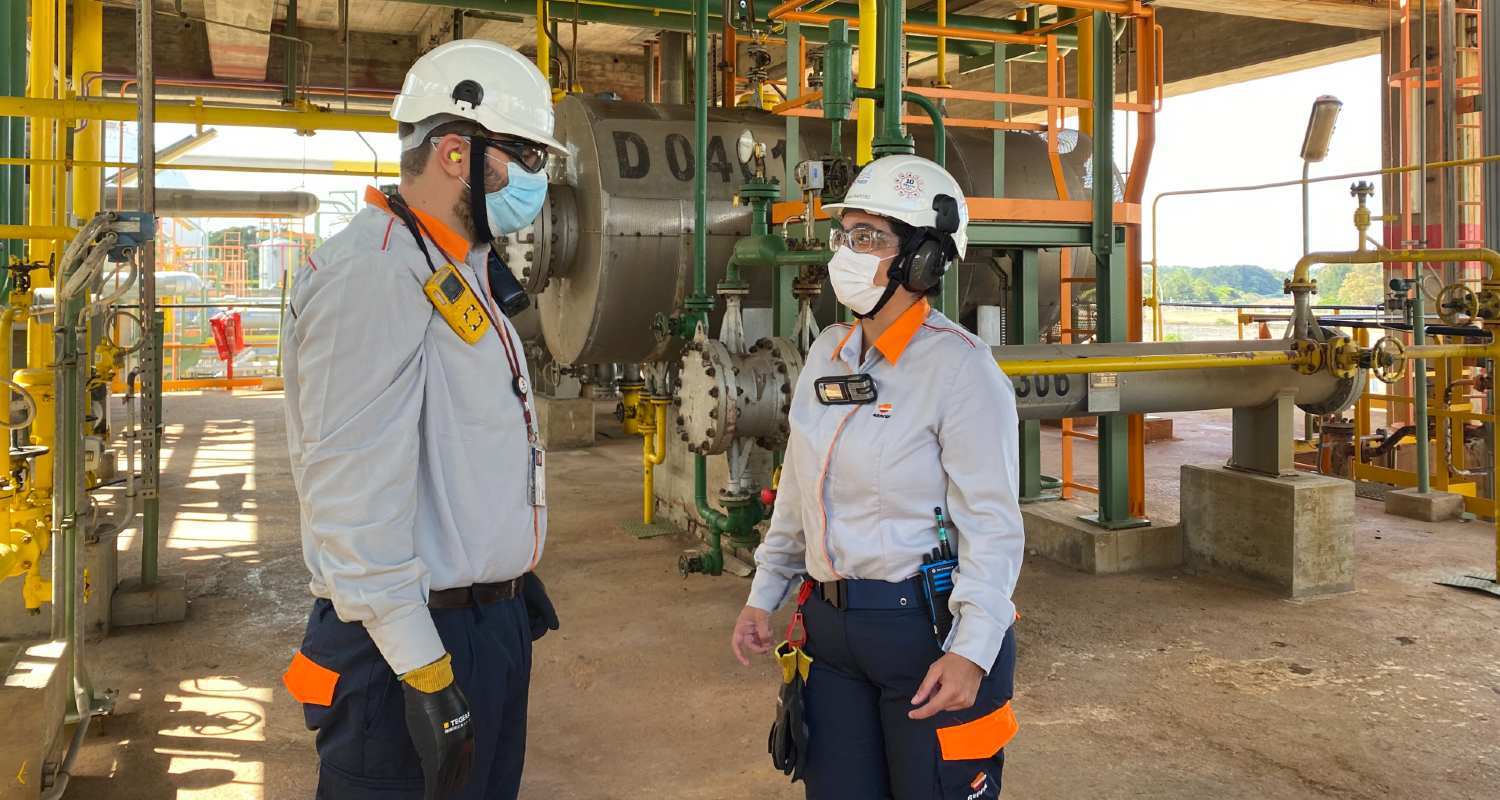 Dos empleados usando casco y mascarilla